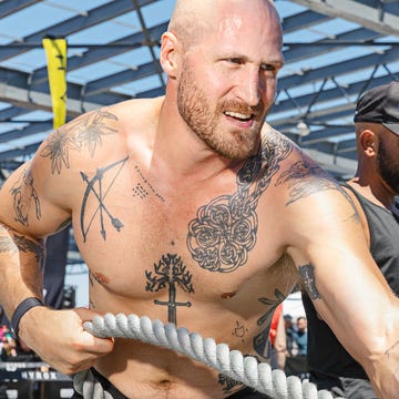 Two individuals engaged in a rope pulling exercise during a fitness event.