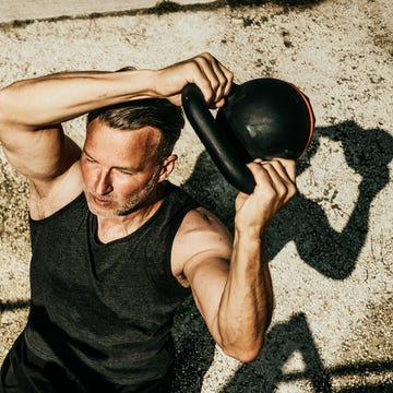 Person exercising with a kettlebell outdoors.