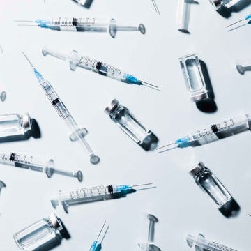 Syringes and vials arranged on a surface.