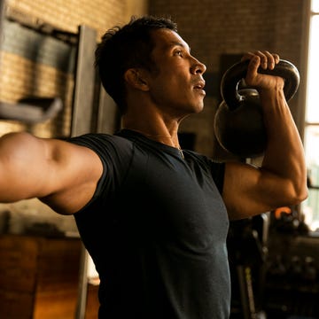 Person performing a kettlebell exercise in a gym setting