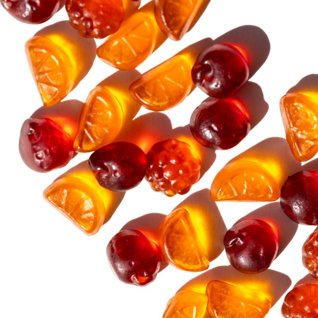 Diagonal Gummies Pattern neatly aligned citrus and berry gummies form a dynamic diagonal across bright white selective focus, vitamins and healthy snack for kids promote healthy food, nutrition and healthy life
