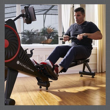 Rowing exercise setup with a person using a rowing machine indoors.