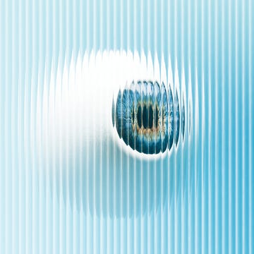 a hovering eyeball obscured by reeded glass