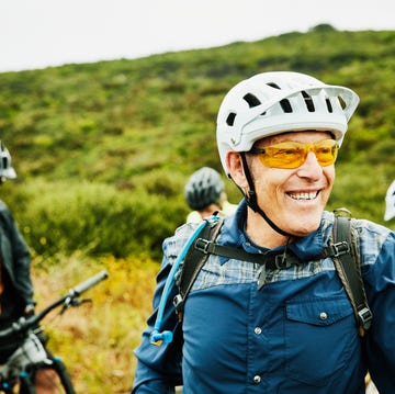 portrait of smiling senior man hanging out with friends before early morning mountain bike ride