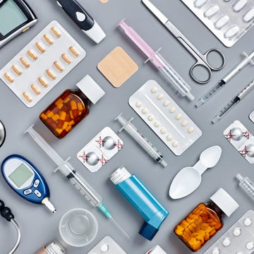 directly above flat lay flat lay shot of various medical supplies. full frame shot of medicines placed with syringes and diagnostic tools. all are on gray background. knolling concept.