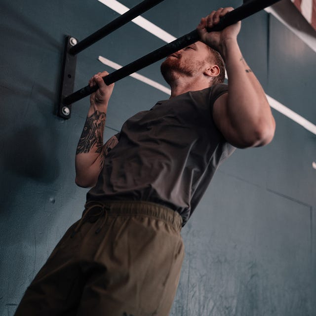 Individual performing a pull-up on a bar. Individual performing a pull-up on a bar.