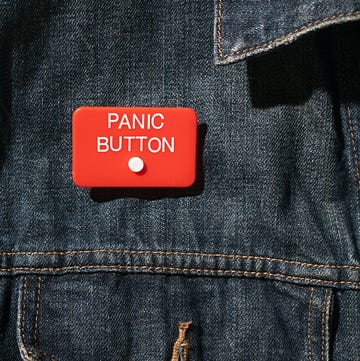 close up of panic button worn on denim jacket anxiety nervous
