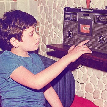 vintage teenage boy playing music on a radio cassette recorder