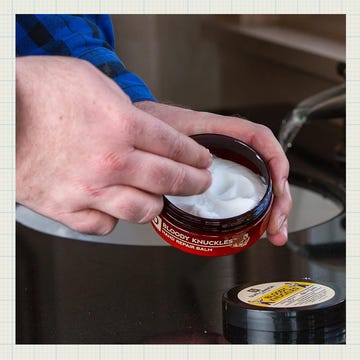 Hand applying hand cream from a container, with other products displayed.