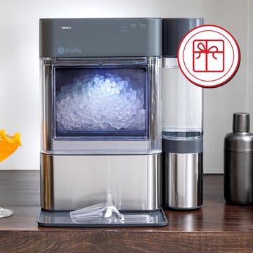 Ice maker with cocktails and bar tools in a modern kitchen setting.