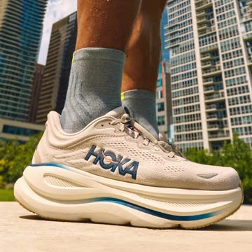 Close-up of a sneaker outdoors with a city skyline in the background. Close-up of a sneaker outdoors with a city skyline in the background.