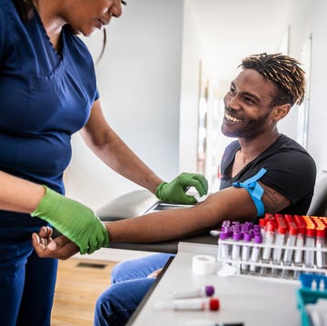 female nurse drawing blood sample from young man in medical office