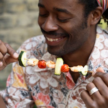 man really diving into a shrimp kebab with zucchini, which is so keto friendly he doesn't even know it