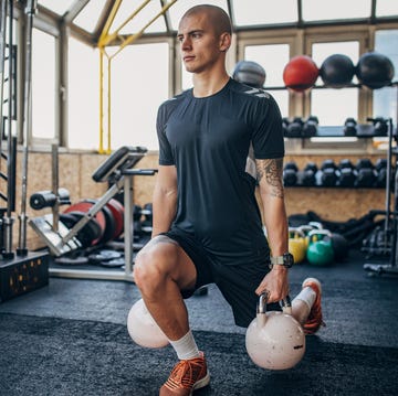 one man, young man exercises with kettlebells in gym.