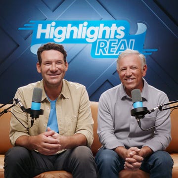 two individuals seated on a couch with microphones showcasing a podcast or interview setting