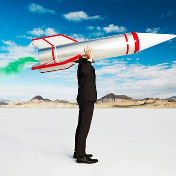 a man holds a smoking rocket on his shoulder