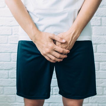 man wearing shorts holding genitals men's health, venereologist, sexual disease