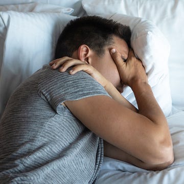man with fatigue next to measles viruses under a microscope