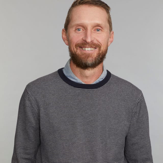 man wearing a striped sweater and a collared shirt