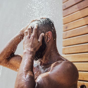 mid adult man taking a shower outdoors