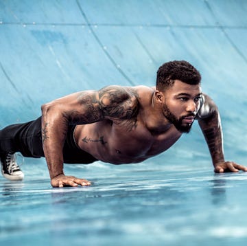 Tattooed physical athlete doing pushups on sports field tattooed physical athlete doing pushups on sports field