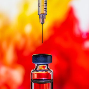 syringe going into a medication vial with a red background