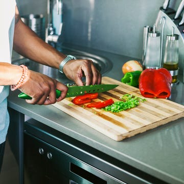 young man cutting vegetables in his kitchen