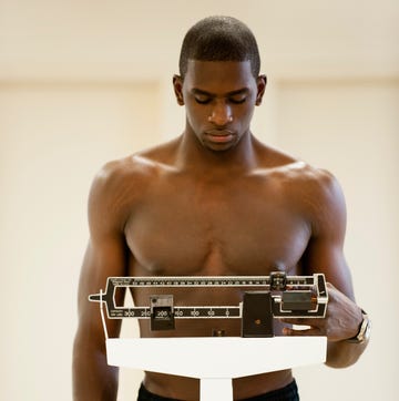 Young man standing on weight scale