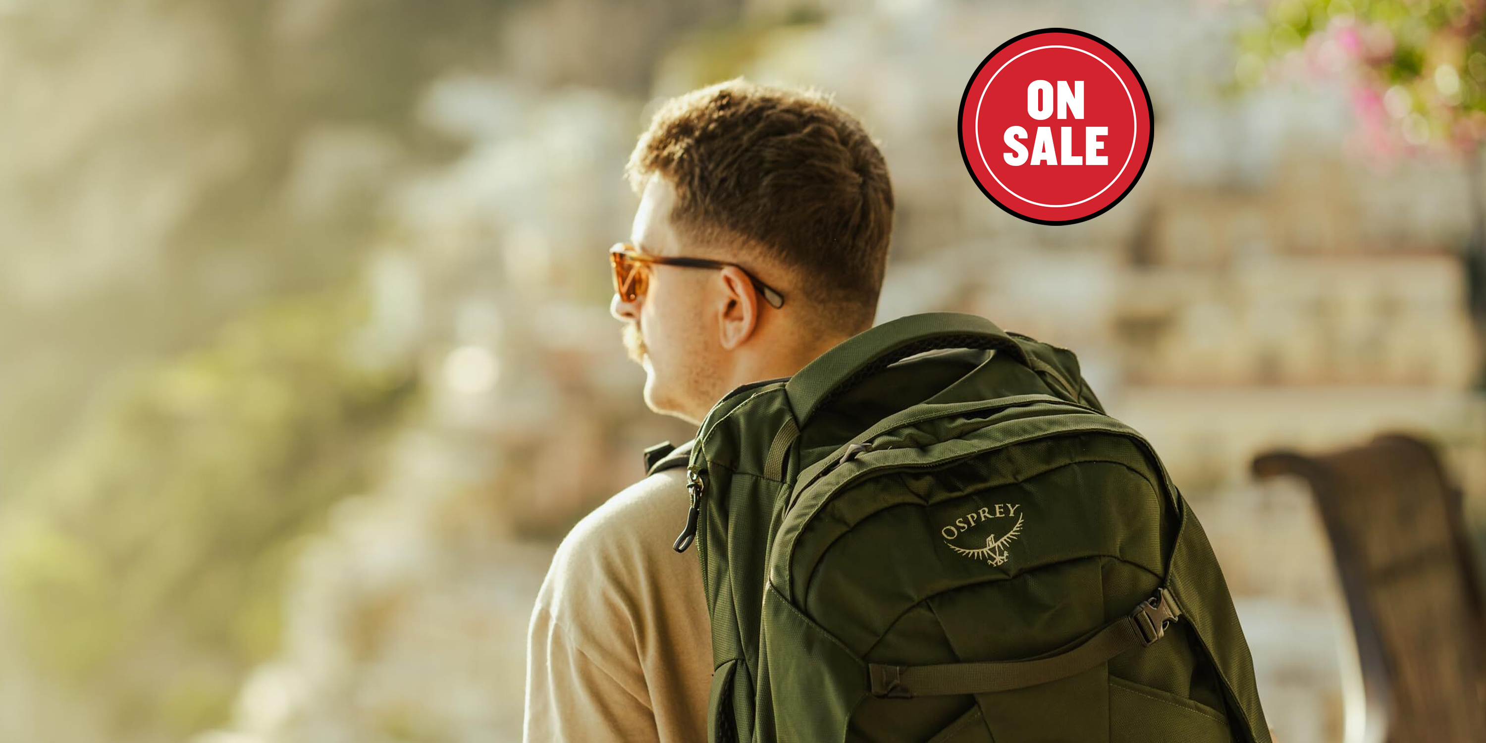 Back view of a person with a green backpack against a scenic backdrop.