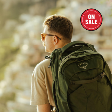 Back view of a person with a green backpack against a scenic backdrop. Back view of a person with a green backpack against a scenic backdrop.